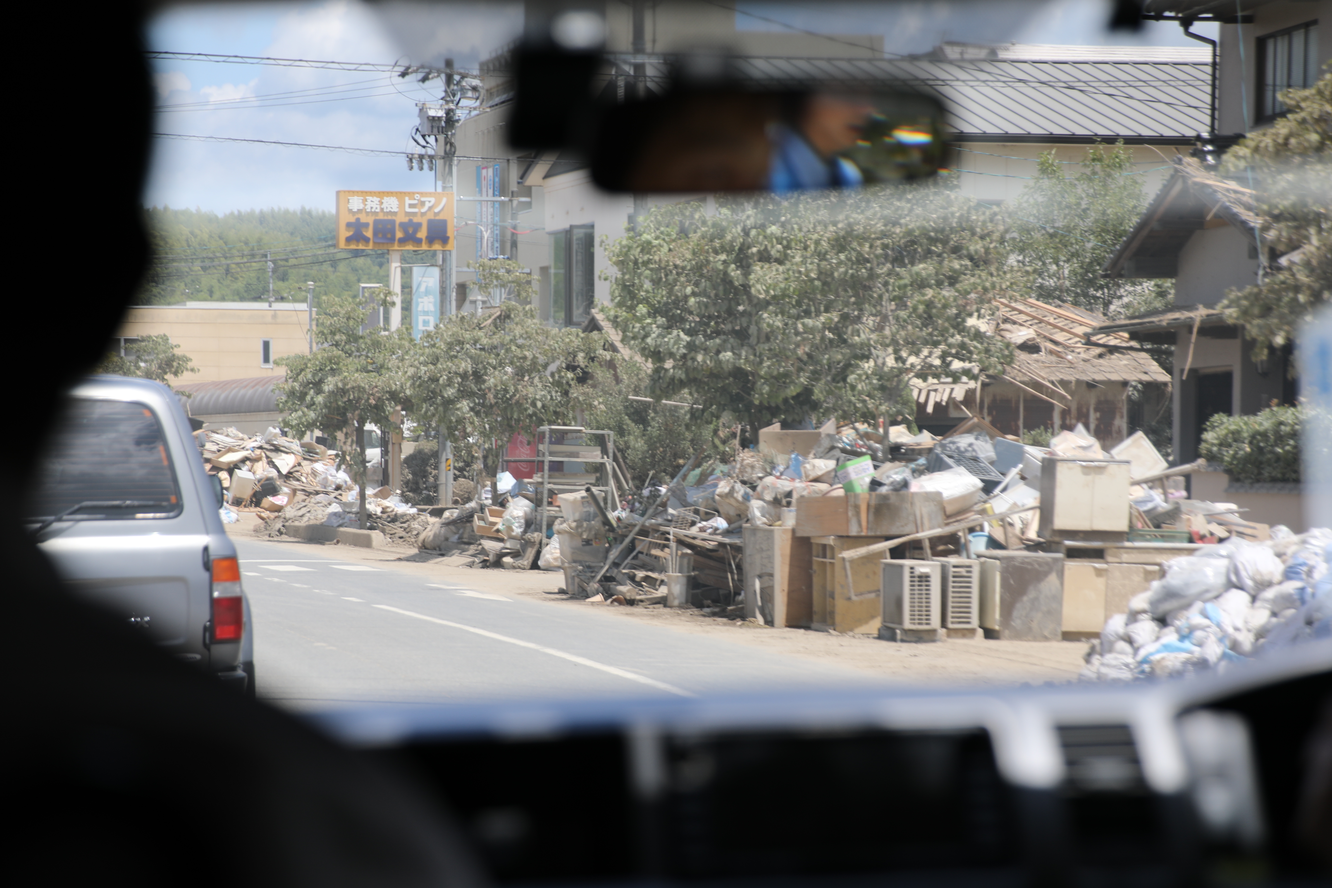 道路脇に積み上げられた家具や電化製品（倉敷市真備町付近）